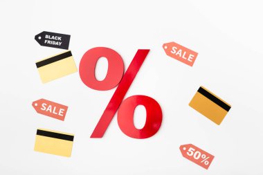 Top view of percent sign near credit cards and price tags with sale lettering on white background clipart