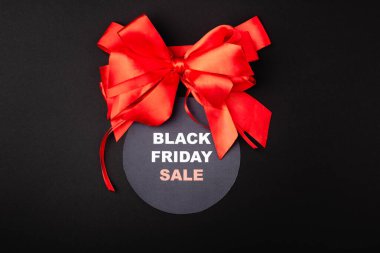 Top view of red bow with black friday sale on circle on black background  clipart