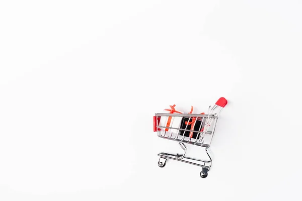 白い背景にショッピングカートでおもちゃの贈り物のトップビュー — ストック写真