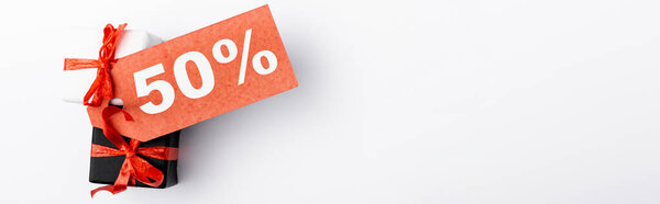 Панорамный снимок маленьких подарочных коробок с ценником на 50% знак на белом фоне