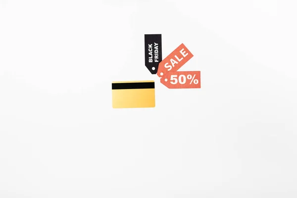 黒の金曜日と白の背景に販売レタリングと価格タグ近くのクレジットカードのトップビュー — ストック写真