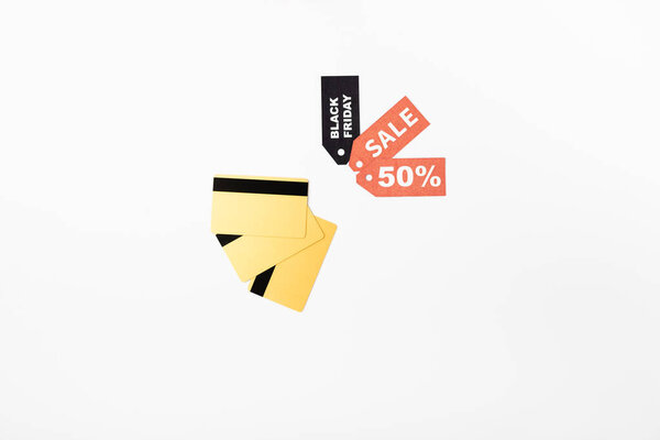 Top view of credit cards and price tags with black friday and sale lettering on white background