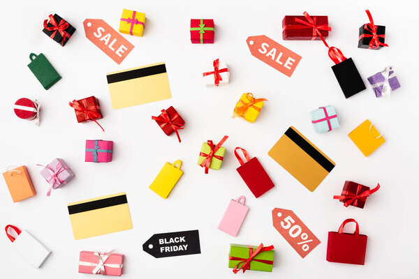 Вид сверху кредитных карт с ценниками и игрушечными сумками для покупок на белом фоне