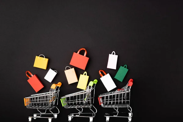 Top View Toy Carts Colorful Shopping Bags Black Background — Stock Photo, Image