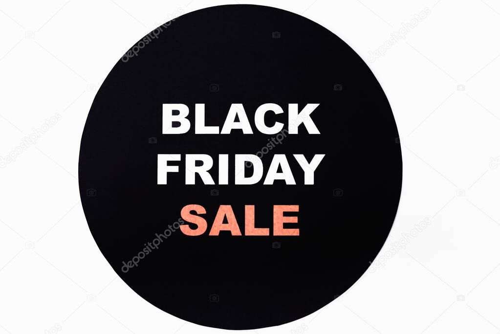 Top view of black friday sale lettering on black circle on white background