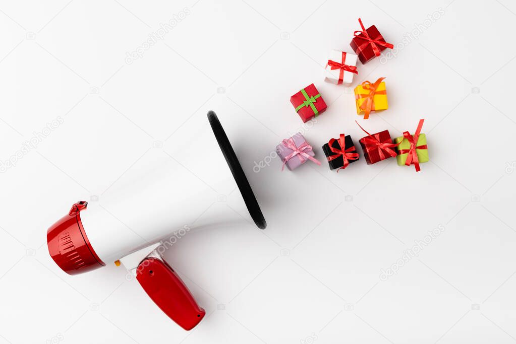 Top view of loudspeaker and small gift boxes on white background