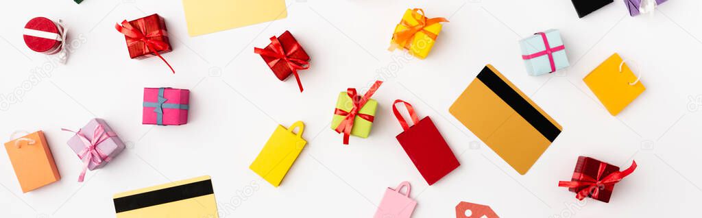 Panoramic orientation of credit cards and toy shopping bags and gifts on white background