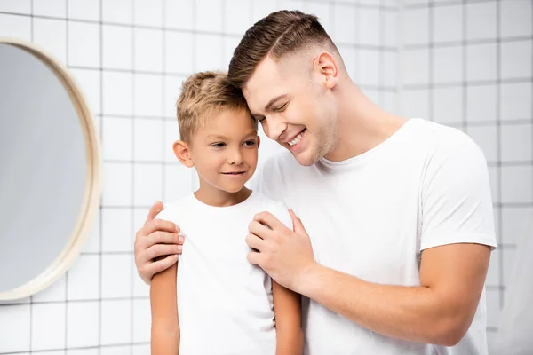 Sonriente Papá Abrazando Hijo Cerca Espejo Redondo Baño —  Fotos de Stock