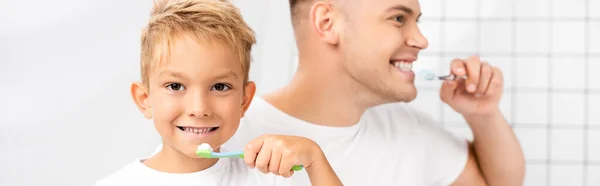 Sonriente Hijo Con Cepillo Dientes Mirando Cámara Pie Cerca Padre —  Fotos de Stock