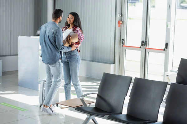 Hombre Sosteniendo Envuelto Flores Mientras Encuentra Feliz Afroamericano Novia Aeropuerto —  Fotos de Stock