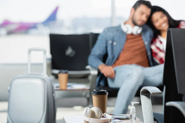 Wireless Headphones Bottle Sanitizer Disposable Cup Interracial Couple Airport Blurred — Stock Photo, Image