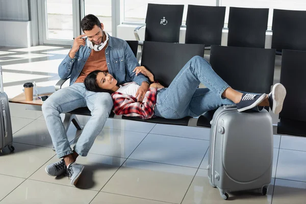 Glückliche Afroamerikanerin Liegt Neben Fröhlichem Mann Abflughalle Des Flughafens — Stockfoto