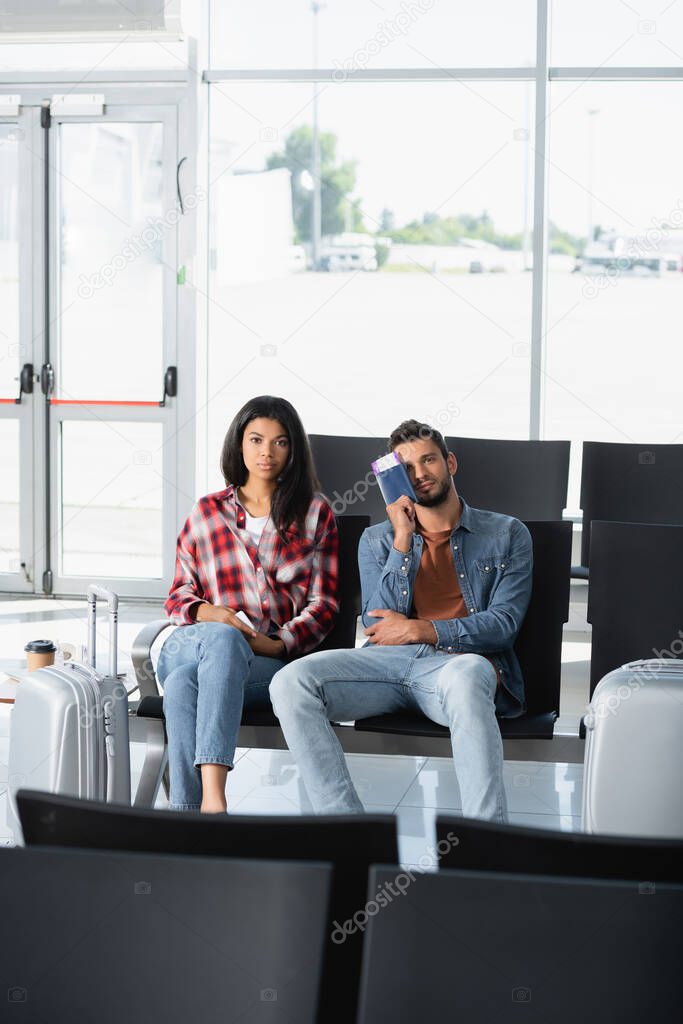 interracial passengers holding passports with boarding pass in airport