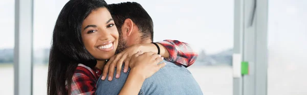 Happy African American Woman Hugging Man Airport Banner — Stock Photo, Image