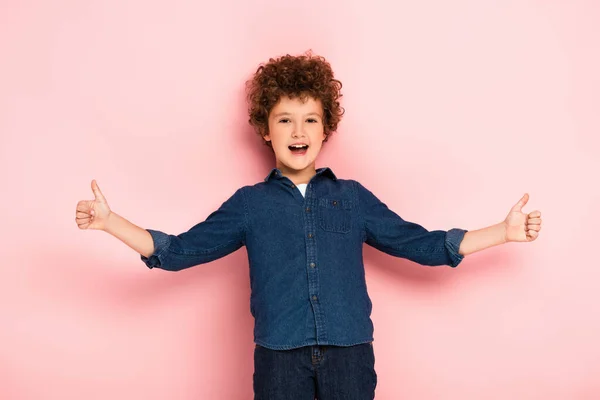 Joyful Curly Boy Outstretched Hands Showing Thumbs Pink — Stock Photo, Image