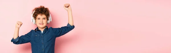 Panoramic Shot Joyful Curly Boy Listening Music Wireless Headphones Pink — Stock Photo, Image