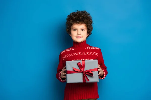 Curly Boy Red Sweater Ornament Holding Present Blue — Stock Photo, Image