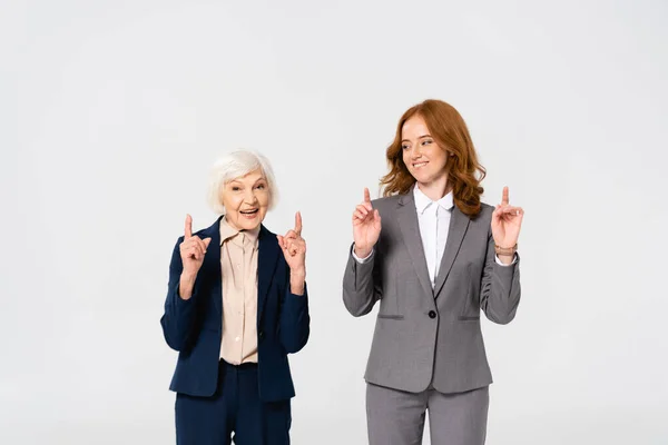Lächelnde Geschäftsfrauen Zeigen Mit Erhobenem Zeigefinger Auf Grau — Stockfoto