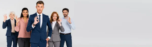 Positive Multiethnic Businesspeople Looking Camera While Showing Gesture Isolated Grey — Stock Photo, Image