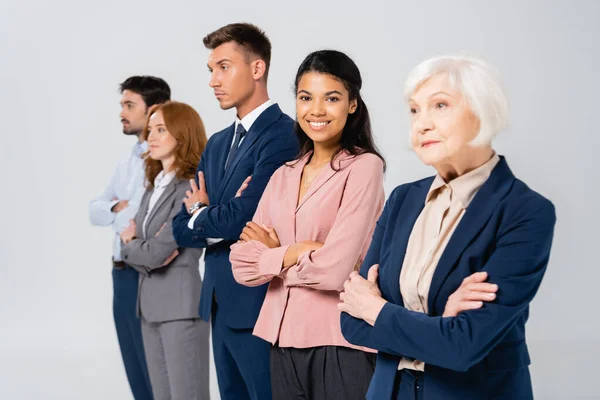 African American Businesswoman Smiling Camera Colleagues Crossed Arms Blurred Background — Stock Photo, Image