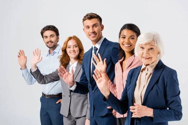 Smiling Businessman Waving Hand Camera Multicultural Colleagues Blurred Foreground Isolated — Stock Photo, Image