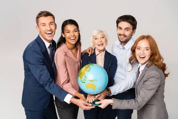 Cheerful Multiethnic Businesspeople Holding Globe While Looking Camera Isolated Grey — Stock Photo, Image