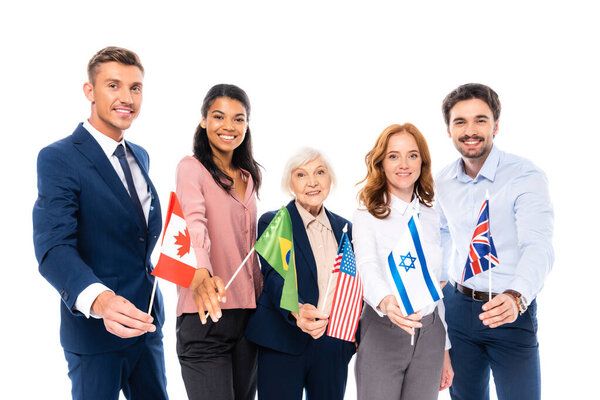 Smiling multiethnic businesspeople holding flags of countries isolated on white