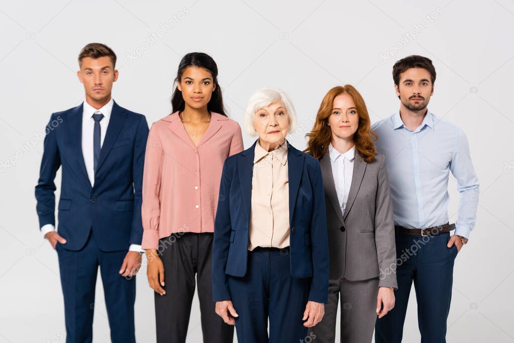 Multicultural businesspeople looking at camera isolated on grey