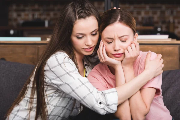 Junge Frau feuert weinende Freundin zu Hause an — Stockfoto