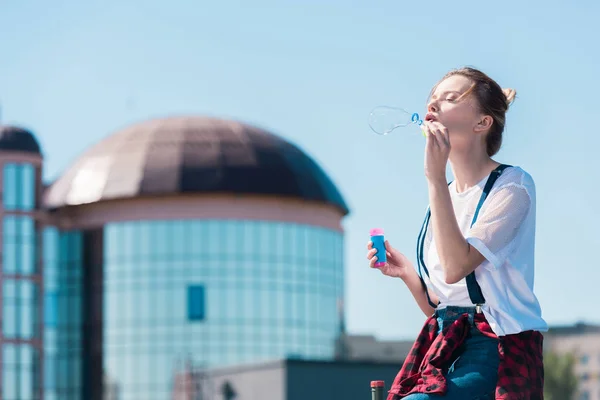 Young woman using bubble blower at rooftop — Stock Photo