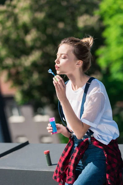 Attractive young woman using bubble blower at rooftop — Stock Photo