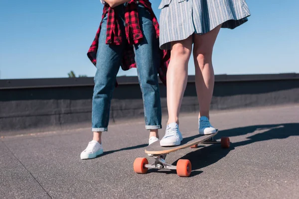 Schnappschuss einer Frau, die ihrer Freundin das Skateboardfahren beibringt — Stockfoto