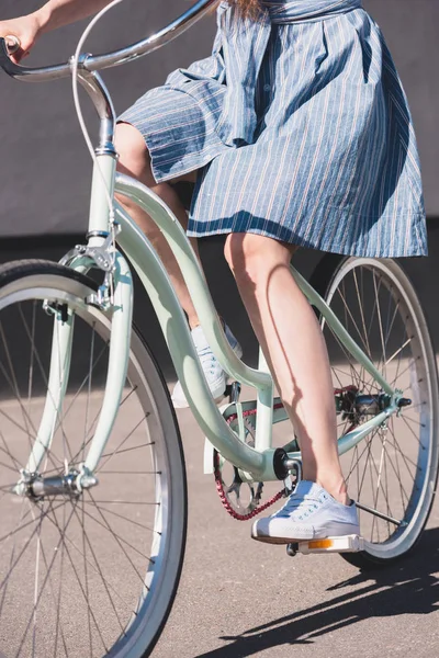 Cropped shot of woman riding on bicycle at city street — Stock Photo