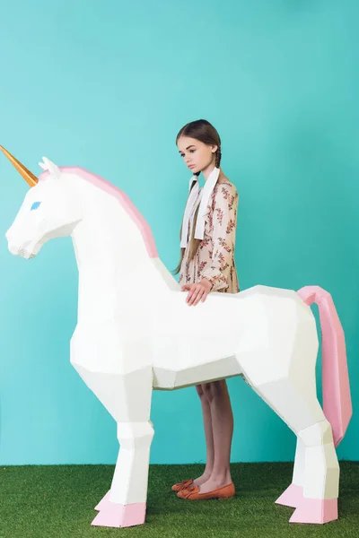 Fashionable teen girl with big white unicorn on turquoise — Stock Photo