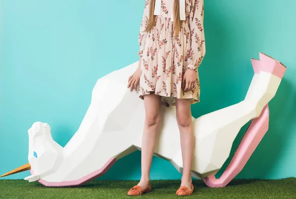 Cropped view of model posing with big unicorn upside down, on blue — Stock Photo