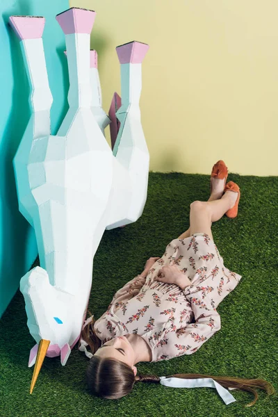 Élégant jeune fille couché avec grande licorne blanche — Photo de stock