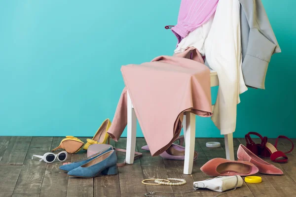 Messy room with elegant fashionable clothes and shoes on chair — Stock Photo