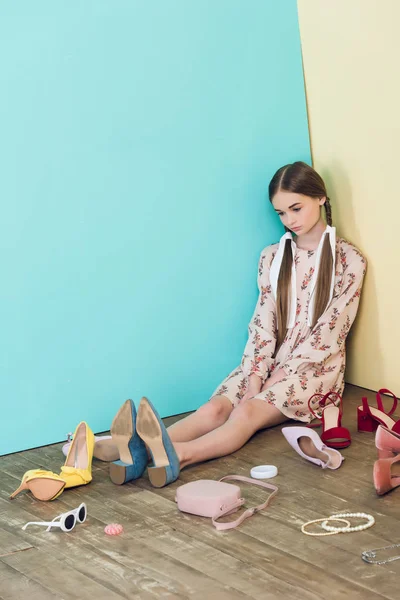 Sconvolto ragazza adolescente alla moda seduto sul pavimento con disordine — Foto stock