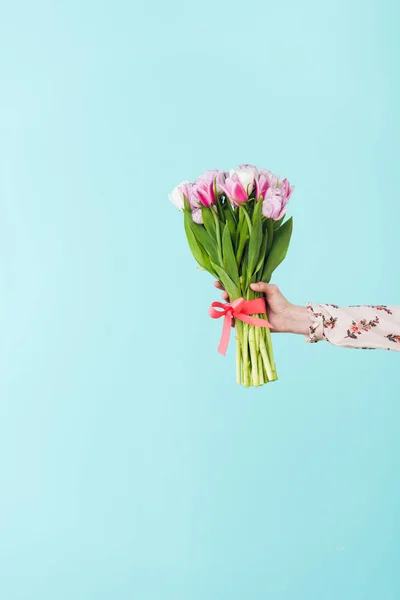 Partial view of girl holding bouquet of tulips, isolated on turquoise — Stock Photo