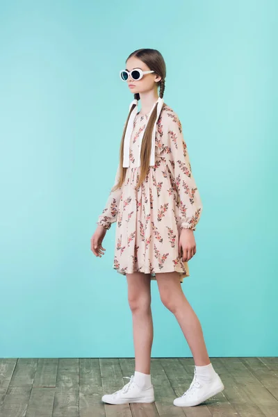 Hermosa chica con trenzas en vestido de verano y gafas de sol, en turquesa - foto de stock