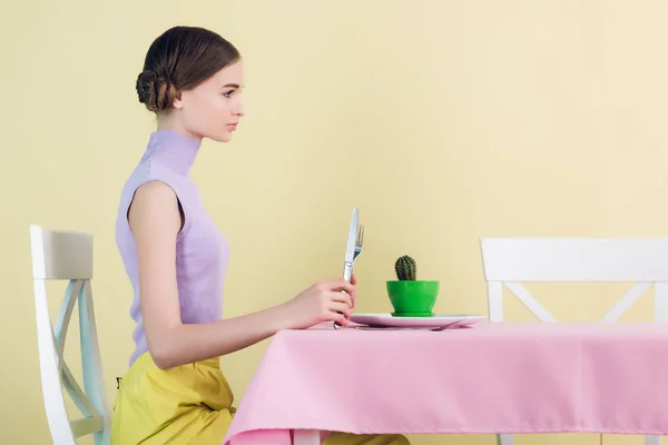 Vista laterale della ragazza che mangia cactus con forchetta e coltello, concetto di dieta — Foto stock