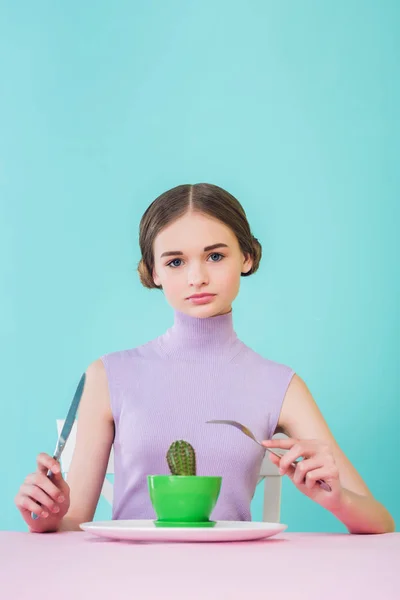 Stylish female teenager eating cactus with fork and knife, diet concept — Stock Photo