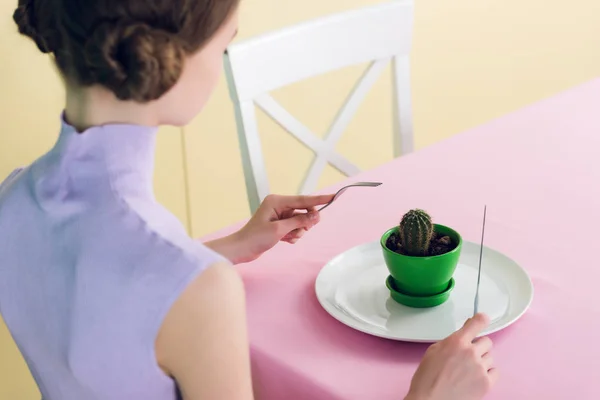 Female teenager eating cactus with fork and knife, diet concept — Stock Photo