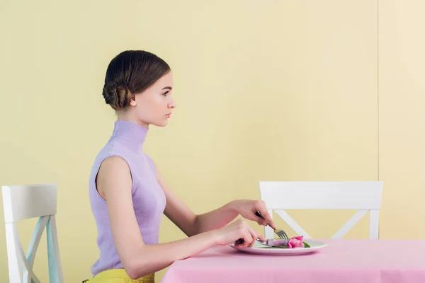 Hermosa chica joven comer flor de tulipán, concepto de dieta - foto de stock