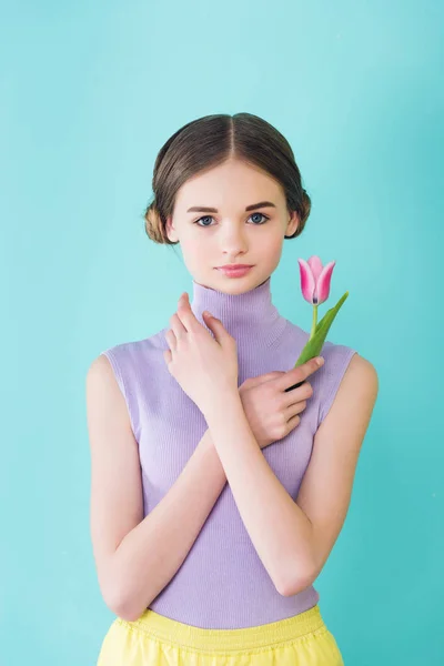 Beautiful tender teenager posing with tulip flower, isolated on turquoise — Stock Photo