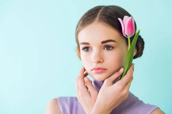 Portrait of tender youth girl with spring flower, isolated on turquoise — Stock Photo