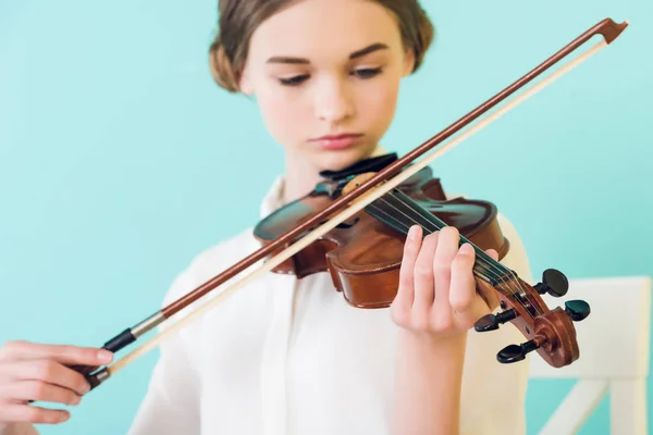 Красивая девушка, играющая на скрипке, изолированная на голубом — стоковое фото