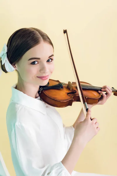 Menina adolescente atraente tocando violino, isolado no amarelo — Fotografia de Stock