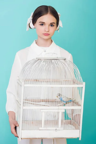 Adolescent fille en blanc tenue cage avec perroquet, isolé sur turquoise — Photo de stock