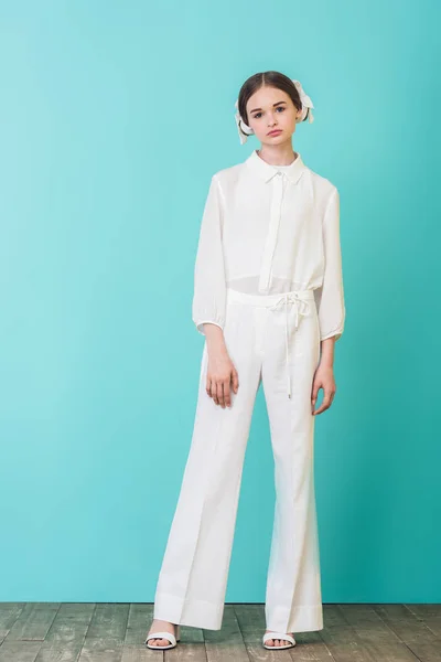 Jeune fille à la mode posant en tenue blanche sur turquoise — Photo de stock
